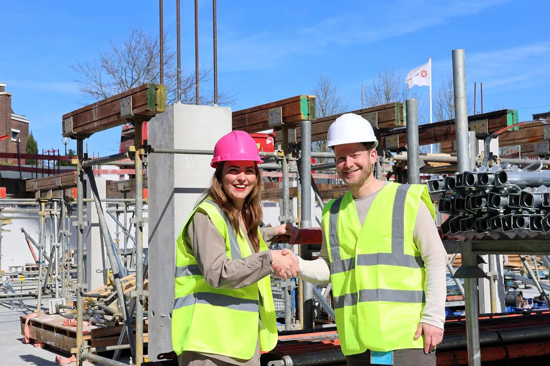 Op de bouwplaats van Hoofddorp Centrum bezegelen Edo Ridder en Esther Nooijen-Moeke de samenwerking