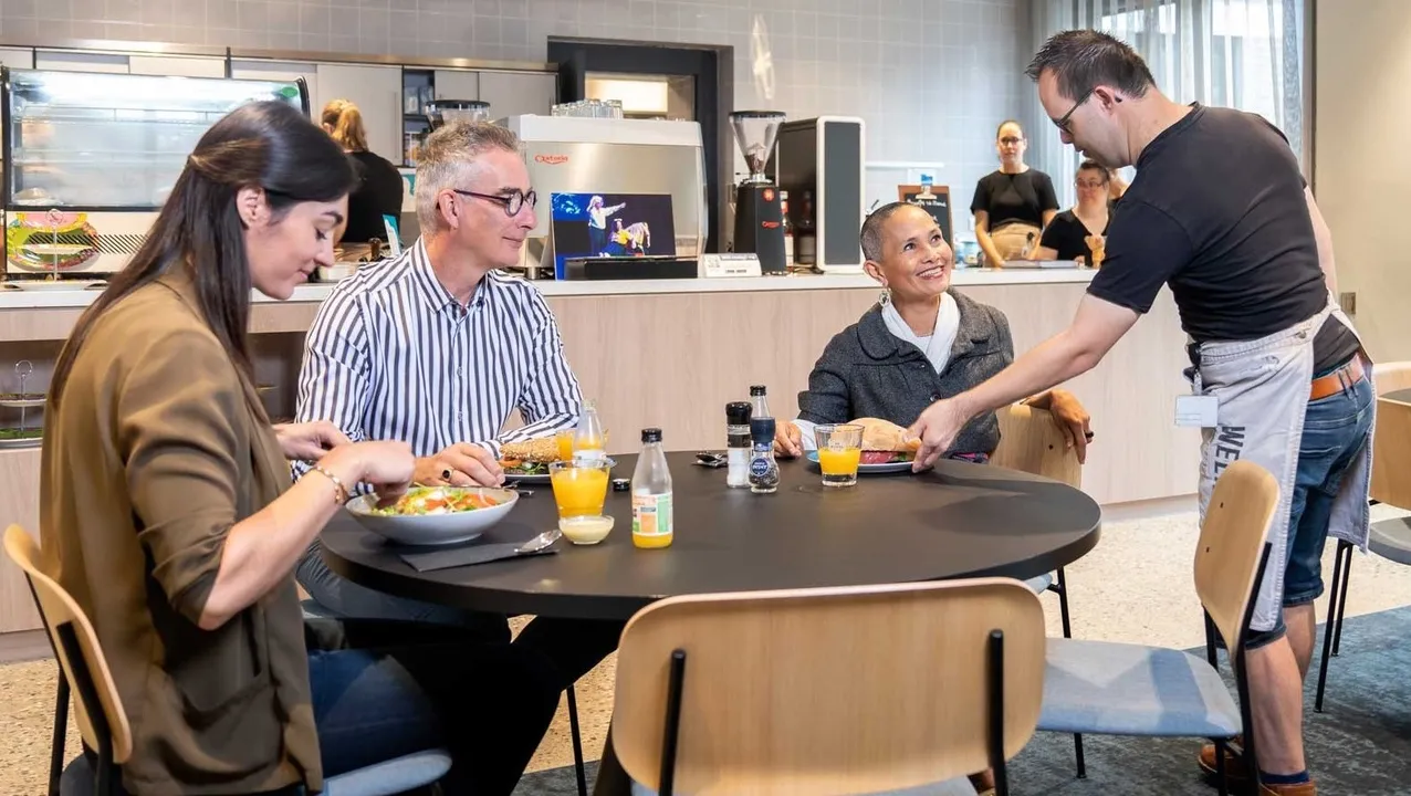 Een aantal collega's zijn aan het lunchen in het werk- lunchcafé. Een aantal collega's zijn aan het lunchen in het werk- lunchcafé.